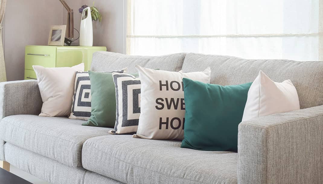 Decoración de una sala con cojines decorativos de diferentes colores, estampados y texturas